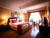 Talisman Hotel auf Sao Miguel – Gemütliches Doppelzimmer mit warmem Ambiente und bequemen Betten, ideal für entspannende Nächte.