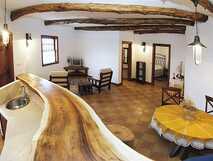 Moinho de Pedra auf Graciosa, gemütlicher und rustikaler Wohn- und Essbereich mit natürlichem Holztresen und traditionellem Ambiente.