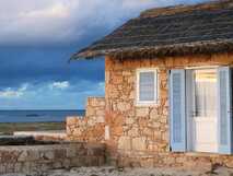 Guesthouse Spinguera Ecolodge auf Boa Vista, idyllisches Steinhaus mit blauem Fensterladen und Meerblick für erholsame, naturnahe Ferien.