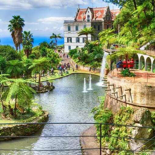 Blick auf den Monte Palace Tropical Garden mit exotischer Vegetation, fernöstlichen Skulpturen und Wasserbecken auf Madeira