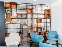 Canadiano Urban Nature Hotel auf Sao Miguel – Moderne Lounge mit stilvollen Sesseln und offener Regalkonstruktion, ideal zum Entspannen und Verweilen.