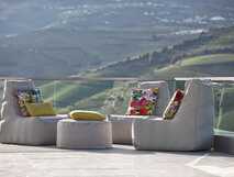 Delfim Douro Hotel- Hotelterrasse mit gemütlichen Sitzgelegenheiten im Hintergrund die Weinberge