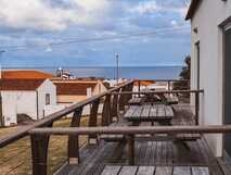 Guesthouse Comodoro auf Flores, gemütliche Holzbalkone mit Sitzgelegenheit und Blick aufs Meer.
