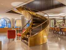 Acores Atlantico Grand Hotel auf Sao Miguel – Elegante Lobby mit goldener Wendeltreppe und gemütlicher Bar, ideal zum Entspannen bei picotours.