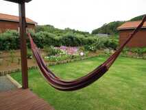 Sitio da Assumada auf Flores – Entspannen Sie in einer gemütlichen Hängematte mit Blick auf einen blühenden Garten in ruhiger Natur.