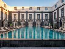 Vila Gale Collection Hotel auf Sao Miguel, eleganter Innenhof mit großzügigem Pool und komfortablen Liegen für entspannten Urlaub bei picotours.