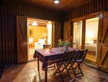 Quinta dos Curubas auf Sao Miguel, gemütliche Außen-Terrasse mit gedecktem Holztisch und Blick ins einladende Interieur – perfekt für entspannte Abende.