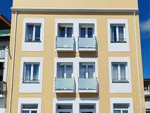 Horta Bay auf Faial: Moderne gelbe Fassade mit Balkonen – zentral gelegenes Gästehaus nahe dem Hafen von Horta