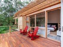 Holzbungalow der Cabanas da Viscondessa mit zwei roten Stühlen auf privater Terrasse im Grünen auf São Jorge