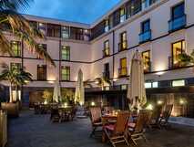 Hotel do Canal auf Faial, stilvoller Innenhof mit gemütlichen Sitzbereichen und tropischen Palmen, ideal für entspannte Abende in moderner und einladender Atmosphäre.
