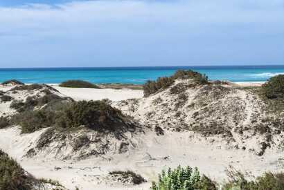 Sanddünen mit Blick auf das türkisfarbene Meer auf der ruhigen Insel Maio, Kapverden.