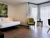 Neat Hotel auf Sao Miguel, modernes und helles Zimmer mit komfortablem Bett und gemütlicher Leseecke, ideal für erholsame Aufenthalte.