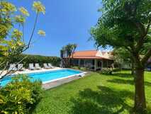 Pool im grünen Garten der Quinta dos Bravos auf den Azoren, umgeben von Sonnenliegen und mediterraner Vegetation