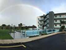 Whales Bay Hotel Apartamentos auf São Miguel, modernes Apartmenthotel mit Außenpool und tropischem Garten unter Regenbogen.