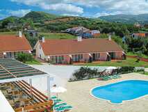 Ferienanlage der Apartamentos Nossa Senhora da Estrela mit Pool, Sonnenliegen und grünem Hügelland auf São Miguel