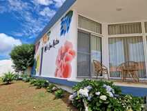 Mil e Uma Noites auf Flores, charmantes Haus mit bunter Blumenfassade und einladender Terrasse.