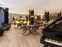 Eleganter Barbereich mit Klavier, Sitzgelegenheiten und stimmungsvoller Beleuchtung