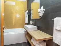 Villas do Mar – modernes Badezimmer mit Badewanne und stilvollem Ambiente.
