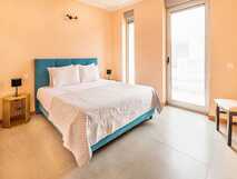 Villas do Mar auf Flores - helles und modernes Schlafzimmer mit großem Fenster und komfortablem Doppelbett.