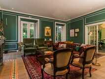 Eleganter Salon im Solar do Cantos mit gemütlichen Sesseln, antikem Kamin und stilvollem Dekor.