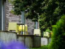 Furnas Lake Villas auf Sao Miguel – moderne Terrassen mit Sitzgelegenheiten umgeben von grüner Natur und blühenden Blumen, ideal für entspannte Urlaubsmomente.