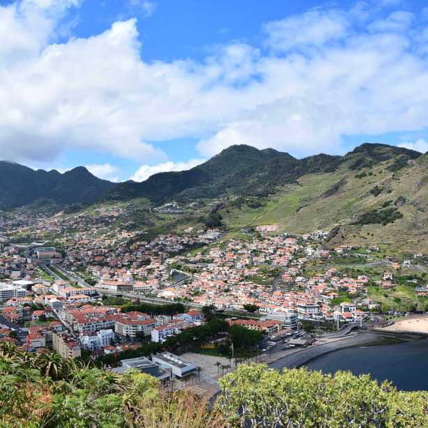 Blick auf Machico Madeira mit Sandstrand und grünen Bergen