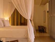 Bom Bom Resort Principe – Elegantes Zimmer mit Moskitonetz für entspannte Nächte in stilvollem Ambiente.