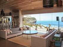 Stilvolle Lounge mit Meerblick im Santa Barbara Eco Beach Resort auf São Miguel, mit Glasfront und gemütlichem Interieur