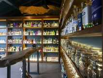 Stilvolle Gin-Bibliothek im Solar Branco Eco Estate mit hunderten Flaschen, Holzregalen und Verkostungstisch.