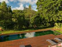 Moderner Poolbereich mit Holzterrasse im grünen Garten des Solar do Cantos Botanic House.