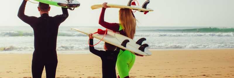 Surferfamilie in Portugal am Strand der Algarve