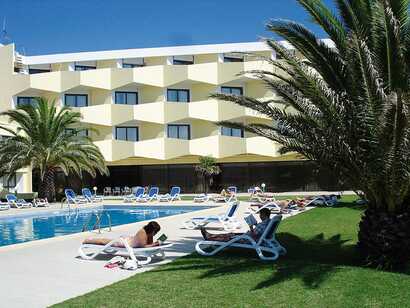 Außenansicht des Caravelas Hotels mit Pool, Sonnenterrasse und Liegestühlen – ideale Lage für Badeurlaub auf Pico