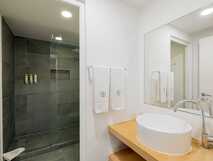 Modernes Badezimmer der Casa Contador mit geräumiger Dusche, Holzdetails und Tageslicht.