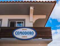 Guesthouse Comodoro auf Flores – charmantes Hotelgebäude mit klarem Himmel.