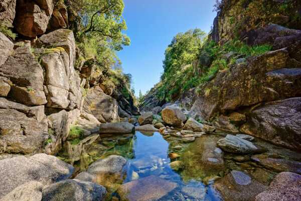 Kleiner Wasserlauf zwischen hohen Felsen im Peneda Geres Nationalpark in Nordportugal.