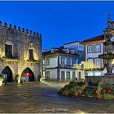 Abendliche Beleuchtung des alten Stadtplatzes in Braga mit historischem Rathaus und Brunnen.