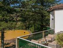 Terra Nostra Garden Hotel auf Sao Miguel, idyllischer Balkon mit Sitzgelegenheit und Blick auf den berühmten Thermalpool inmitten üppiger Natur – perfekte Erholung mit picotours.