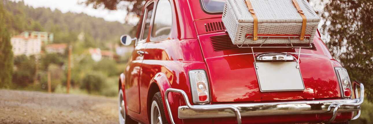 kleines rotes Auto mit Gepäck - Wo gibt es diesen Mietwagen auszuleihen?