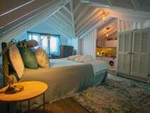 Stilvolles Dachzimmer bei My Bed in Pico mit Doppelbett, gemütlicher Sitzecke, Kochnische und sichtbarem Dachgebälk