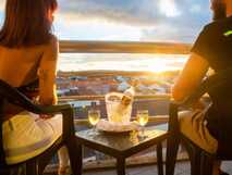 MS Vila Nova Hotel auf Sao Miguel, Genussvoller Sonnenuntergang mit Wein auf der Balkonterrasse über den roten Dächern der Insel – perfekte Entspannung bei picotours.