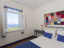 Casa do Monte auf Sao Miguel, gemütliches Zimmer mit Meerblick und farbenfroher Dekoration – perfekte Erholung bei picotours.