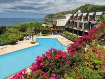 Caloura Hotel Resort auf Sao Miguel, idyllisches Ferienresort mit Meerblick, großem Pool und blühenden Gartenanlagen.