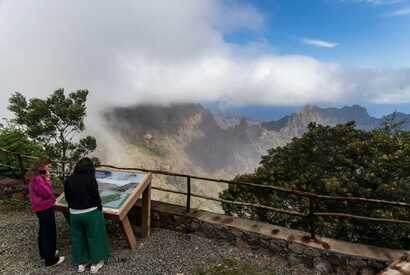 Zwei Frauen betrachten eine Informationstafel mit Aussicht auf die nebelverhangenen Berge von Santo Antão auf Cabo Verde.