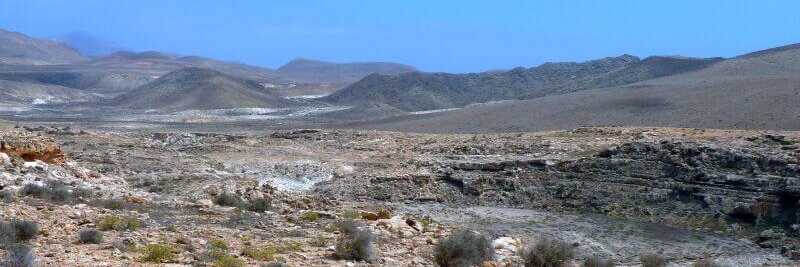 Trockene, wüstenähnliche Landschaft mit Hügeln unter blauem Himmel auf den Kapverden – Beispiel für das aride Klima.