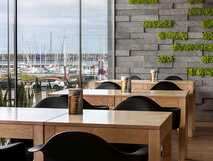 Frühstücksraum im Neat Hotel Avenida mit moderner Holzoptik und Blick auf den Hafen von Ponta Delgada