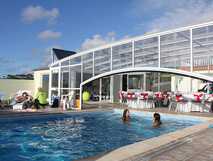 Pension Al-Nova Vista auf den Azoren mit überdachtem Außenpool, Frühstücksbereich und Gästen beim Baden und Entspannen