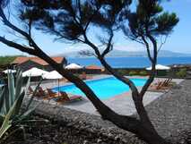 Pocinho Bay mit Pool und Sonnenliegen, umgeben von Lavagestein und Blick aufs Meer auf den Azoren