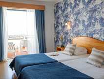 Hotel do Mar auf Sao Miguel, gemütliches Doppelzimmer mit maritimem Flair und Balkon für entspannte Momente mit Meerblick.