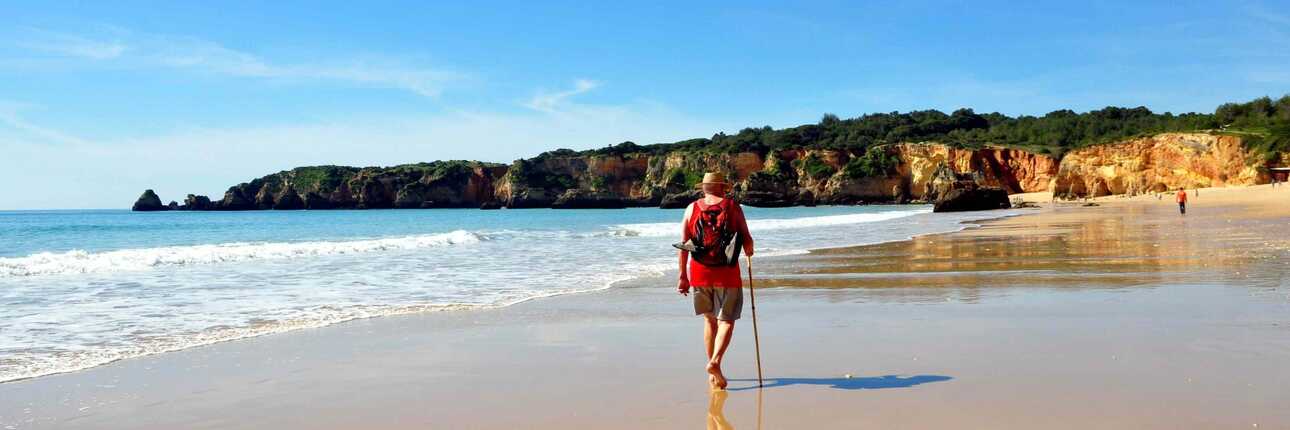 Mann wandert am Strand der Algarve, einer Landschaft in Portugal