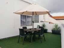 Senhora do Carmo Charm House auf Sao Miguel, gemütliche Außenterrasse mit Sonnenschirm und Sitzbereich für entspannte Momente.